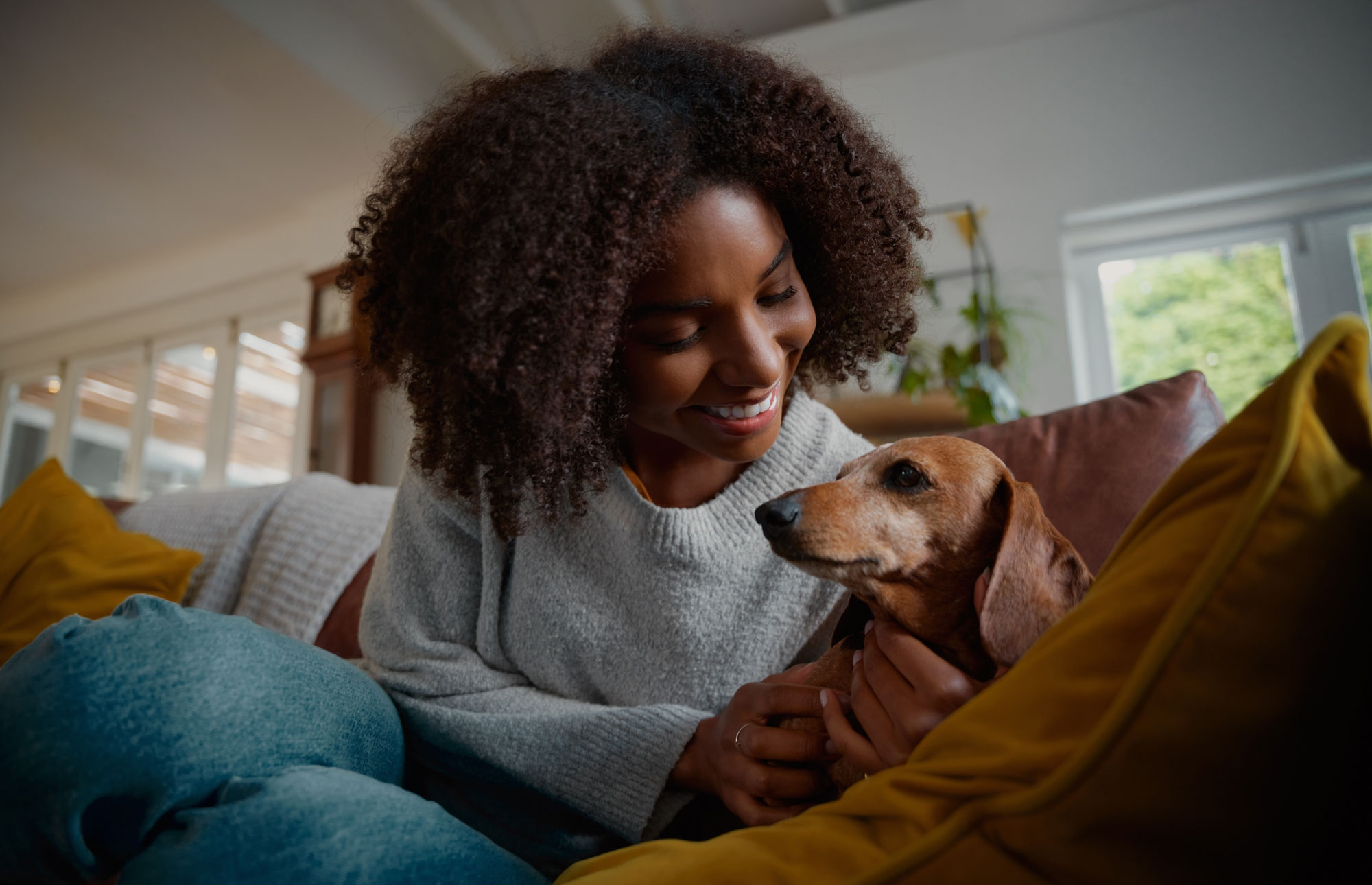 Person with her pet on a loveseat.