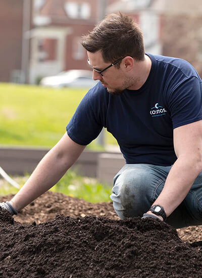 Cosmos employee preparing dirt for planting