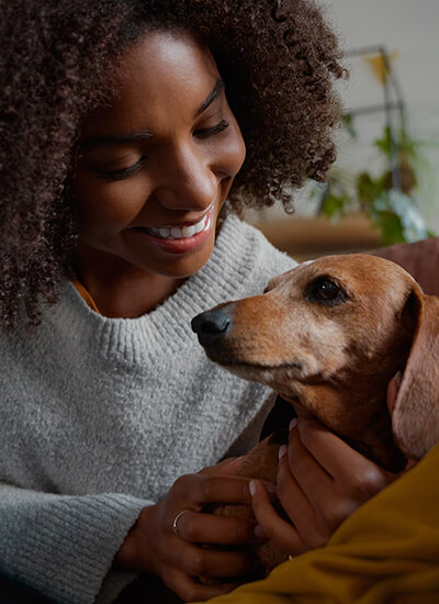 Person with her pet on a loveseat.